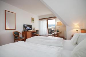 Habitación de hotel con 2 camas blancas y ventana en Landidyll Hotel Zum Alten Schloss, en Kirchensittenbach