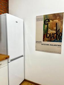 lodówka i plakat na ścianie w obiekcie Bezagenta Rooms Centrum w Warszawie