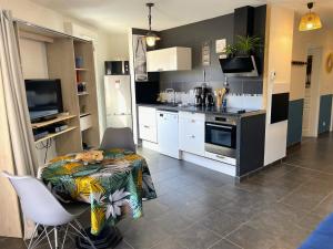 加普的住宿－Marguerite-Gap Centre，一间带桌子的厨房和一间带白色橱柜的厨房