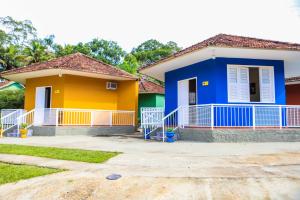 a house with a blue and yellow at Pousada Mama África in Conservatória