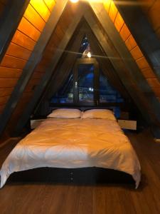a bedroom with a bed in a attic at La KOLTAU A-Frame in Mărişel