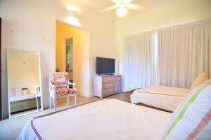 1 Schlafzimmer mit 2 Betten, einem TV und einem Stuhl in der Unterkunft Six Bedrooms Luxury Disco Room Villa in La Romana