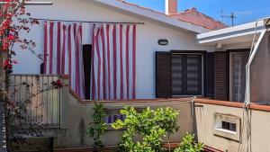 Uma casa com uma bandeira americana ao lado. em Grazioso e confortevole attico, costa sud-ovest em Gonnesa