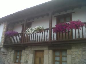 ein Gebäude mit einem Balkon mit Blumen darauf in der Unterkunft El Cabañon de Pimiango in Pimiango
