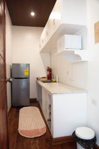 a small kitchen with white cabinets and a refrigerator at Sunset Villas Palauig Zambales in Palauig