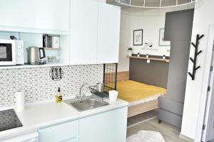 Una pequeña cocina con fregadero y microondas. en Home Apartment LUNA 1, en Skopje 7 fotos más