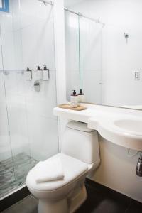 a white bathroom with a toilet and a sink at Hotel Hacienda Santa Clara in Santa Rosa de Cabal