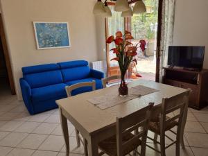 a living room with a table and a blue couch at Orizzonti del Castelluccio Volpe rossa villetta elegante confortevole e rilassante in Brancorsi
