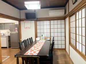 a room with a table with chairs and a kitchen at KIX House 和楽二号館 in Izumi-Sano
