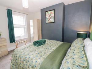 ein Schlafzimmer mit einem Bett mit einem grünen Kissen darauf in der Unterkunft Dobbies Den in Bewdley