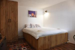a small bedroom with a bed and a wooden cabinet at NeWave Apartment in Strumica