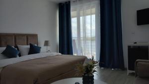 a bedroom with a bed and a large window at Lago d'argento sobe in Veliko Gradište