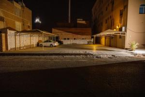 ein Auto parkt nachts auf einem Parkplatz in der Unterkunft غالينا للوحدات السكنية in Abū Qa‘ar