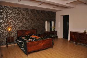 1 dormitorio con 1 cama y una pared con un patrón en Nino Duplex Apartment, en Tiflis