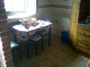 einen Tisch in einer Küche mit einem Tisch und Stühlen in der Unterkunft El Cabañon de Pimiango in Pimiango