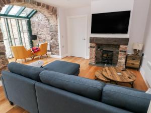 a living room with a blue couch and a fireplace at Skomer Cottage in Haverfordwest