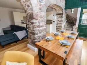 una cucina e un soggiorno con tavolo in legno di Skomer Cottage a Haverfordwest