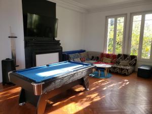a living room with a pool table and a tv at La Casa des Frangins in Saint-Romain-de-Colbosc