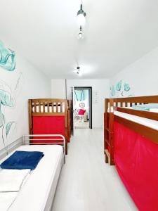 Habitación con 2 camas y sábanas rojas y azules. en Tenerife Experience Hostel en Santa Cruz de Tenerife