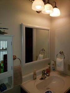 a bathroom with a sink and a mirror at Front of Country shabby chic Home near Ganondagan Historic Site on 10 wooded acres in Victor