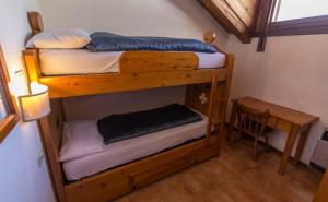 two bunk beds in a room with a desk at Residence Borgo Al Sole in Sappada