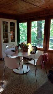 una mesa y sillas en una habitación con ventanas en Waldhaus Wiesengrund en Schwielochsee