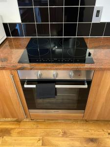 a kitchen with a stove with a counter top at Inverness Highland Apartment in Inverness +16 photos