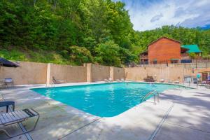 a large swimming pool with a red barn in the background at Aspen's Envy, 4 Bedrooms, Sleeps 16, Pool Table, Hot Tub, Mountain Views in Pigeon Forge