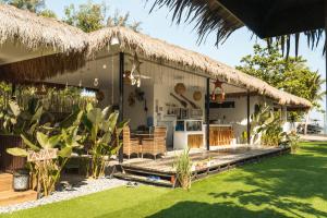a house with a thatch roof and a patio at Sunset Villas Palauig Zambales in Palauig