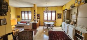 a living room with yellow walls and a table and chairs at Sunflower House in Alessandria