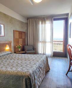 una camera con un letto e una grande finestra di Hotel Castello S. Antonio a Lazise