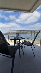 a table and chairs on a balcony with a view of the water at Lago d'argento sobe in Veliko Gradište