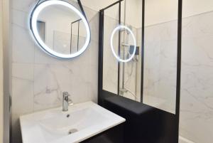 un baño con lavabo y espejo en L'Olivier Centre ville Parking Disneyland 4 personnes et 1 bébé, en Bailly-Romainvilliers 16 fotos más