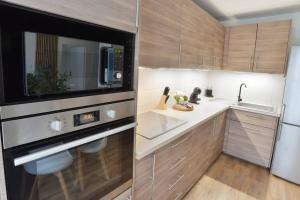 uma cozinha com um lavatório e um micro-ondas em L'Olivier Disneyland JO Paris 2024 avec Parking em Bailly-Romainvilliers