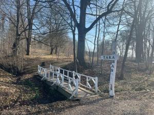 a wooden bridge in a field with a sign at Home of Koknese in Koknese