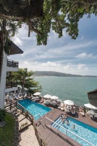 ein Swimmingpool mit Blick auf das Wasser in der Unterkunft Bombinhas Tourist Apart in Bombinhas