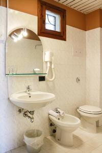 a bathroom with a sink and a toilet and a mirror at Hotel Castello S. Antonio in Lazise