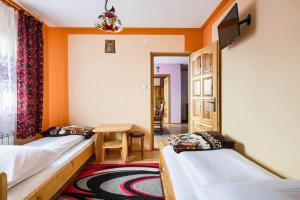 RzepiskaにあるDworek na Wzgórzuのオレンジ色の壁の客室内のベッド2台