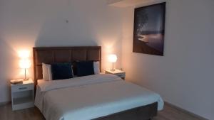 a bedroom with a large bed with two lamps at Lago d'argento sobe in Veliko Gradište