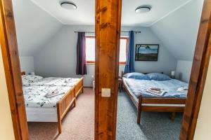 1 dormitorio con 2 camas y espejo en LiBe Apartman en Gyenesdiás