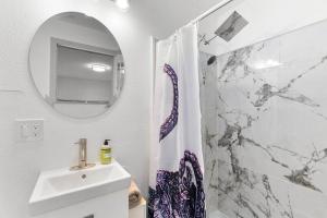 a white bathroom with a sink and a mirror at Hillside in Seattle - updated and well appointed. in Seattle +9 photos