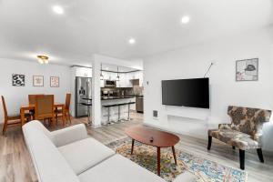 a living room with a couch and a tv and a table at Hillside in Seattle - updated and well appointed. in Seattle