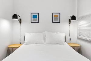 a bedroom with a large white bed and two lamps at Hillside in Seattle - updated and well appointed. in Seattle