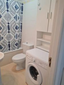 een badkamer met een wasmachine en een toilet bij Los Cancajos Apartamento Acijoa in Los Cancajos