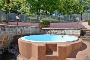 a large circular pool in a yard with a fence at Prázdninový dům-Pension ROLIMPEX in Podkopná Lhota