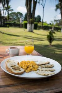 a plate of eggs and toast and a glass of orange juice at Hotel Hacienda Santa Clara in Santa Rosa de Cabal