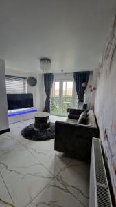 Two bed apartment with balcony Slough,Windsor,Legoland في سلاو: غرفة معيشة مع أريكة وطاولة