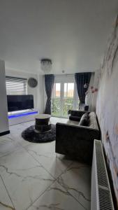 sala de estar con sofá y mesa en Two bed apartment with balcony Slough,Windsor,Legoland, en Slough