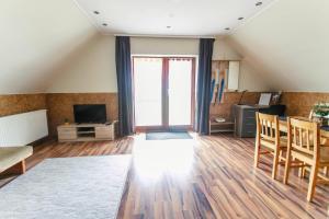 LiBe Apartman في جينيسدياس: غرفة معيشة في العلية مع أريكة وتلفزيون