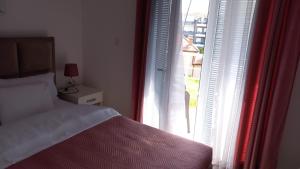 a bedroom with a bed next to a window at Lago d'argento sobe in Veliko Gradište